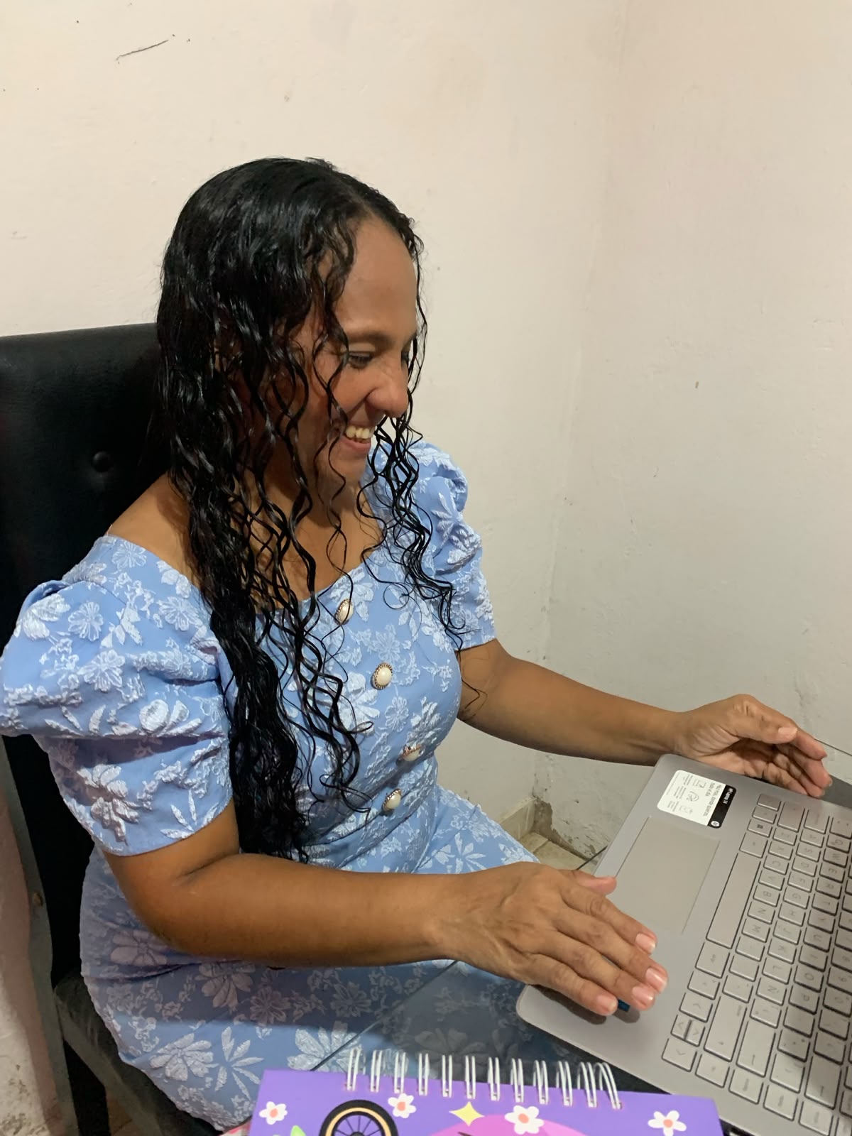 Esther María Causado de perfil, trabajando en su portátil en su espacio de consulta